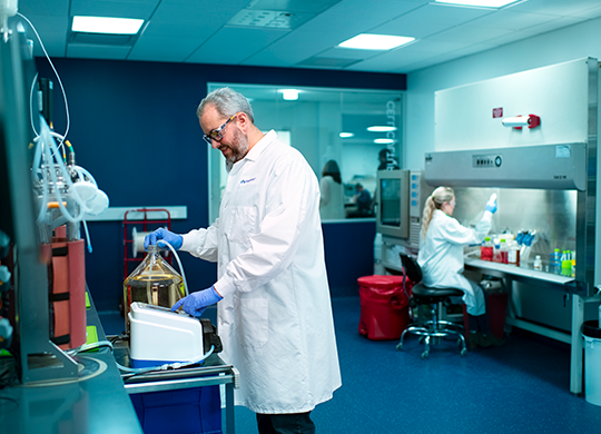 Researcher preparing a cell culture bioreactor Researcher preparing a cell culture bioreactor