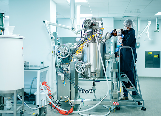Technicians working with pilot plant large bioreactor Technicians working with pilot plant large bioreactor