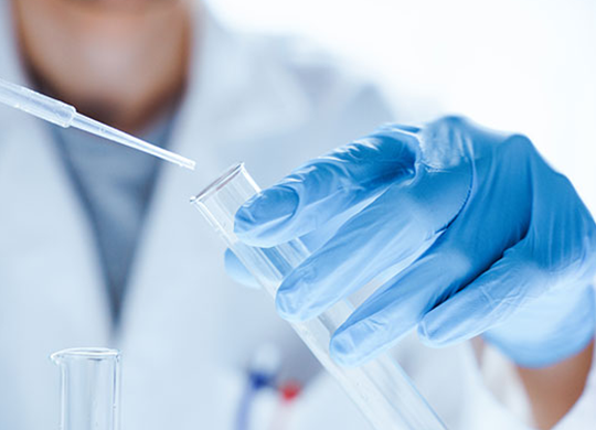 A scientists hand holds a test tube while the other hand uses a pipette to put a solution into the tube.png A scientists hand holds a test tube while the other hand uses a pipette to put a solution into the tube.png