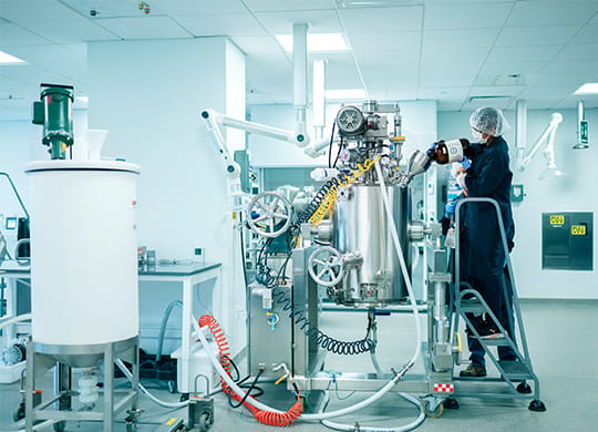 Technicians working with pilot plant large bioreactor Technicians working with pilot plant large bioreactor
