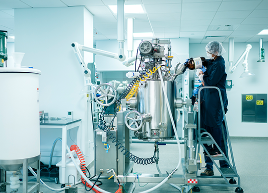 Technicians working with pilot plant large bioreactor Technicians working with pilot plant large bioreactor