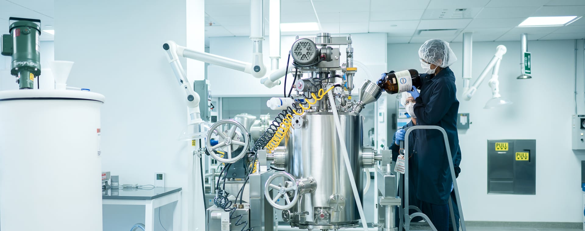 Technicians working with pilot plant large bioreactor Technicians working with pilot plant large bioreactor